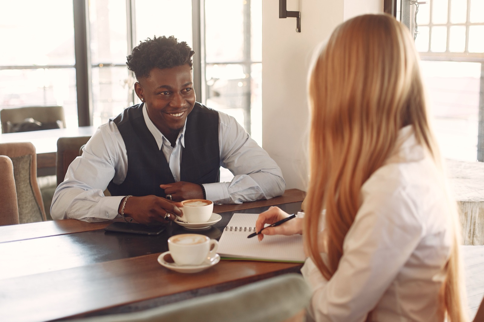 Two people talking over coffee