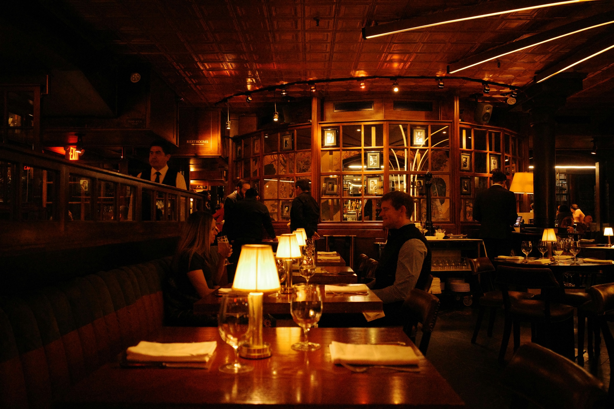 People talking at a lamp-lit restaurant table