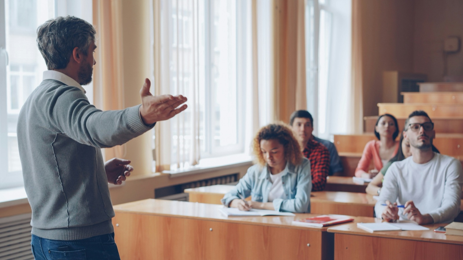 A lecturer speaking to students in a lecture room